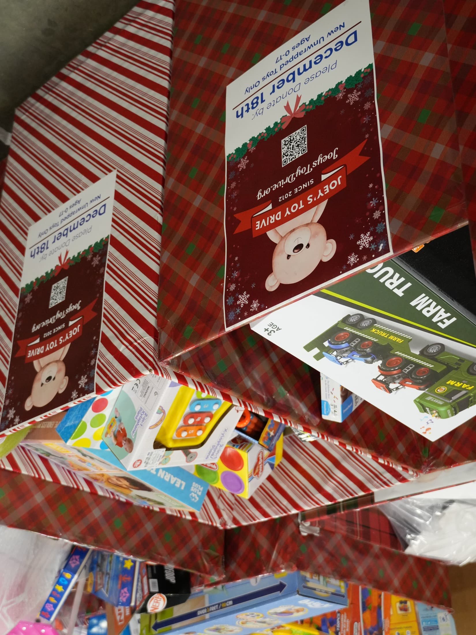 Two collection boxes in plaid and candy-stripe wrap, filled past the brim with new toys