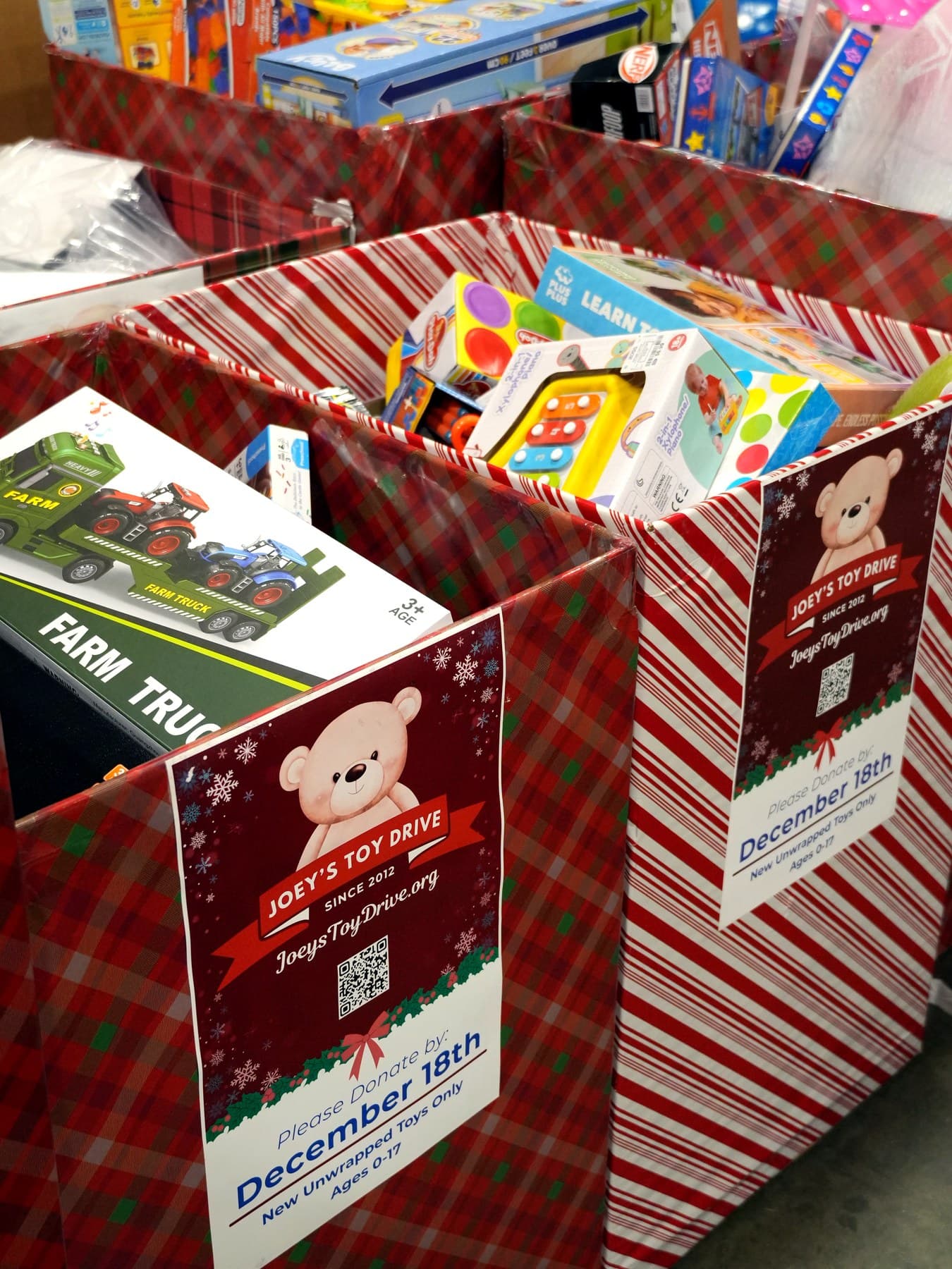 Joey's Toy Drive branded collection boxes filled with donated toys at the San Jose warehouse