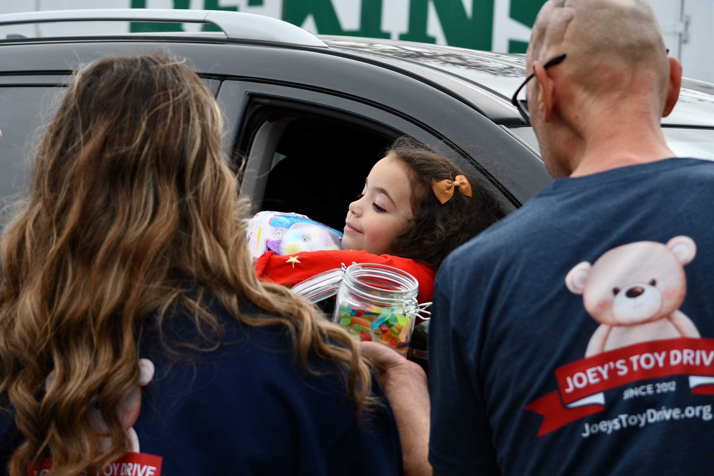Volunteers handing gifts to a family