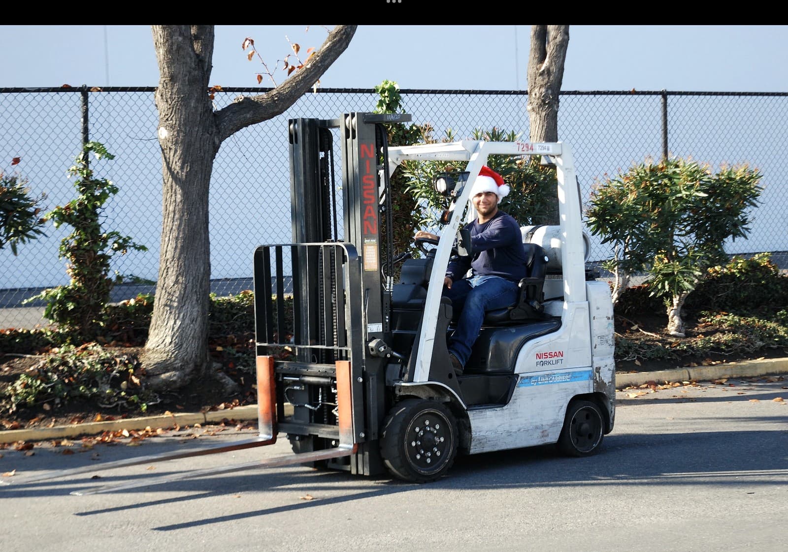 Andrey Dini moving freight on the warehouse forklift, wearing a Santa hat, during the December drive