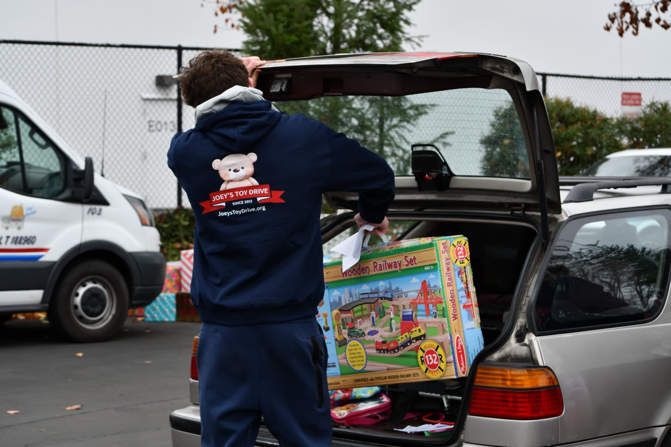 Boxes of donated toys being loaded from a car trunk for Joey's Toy Drive